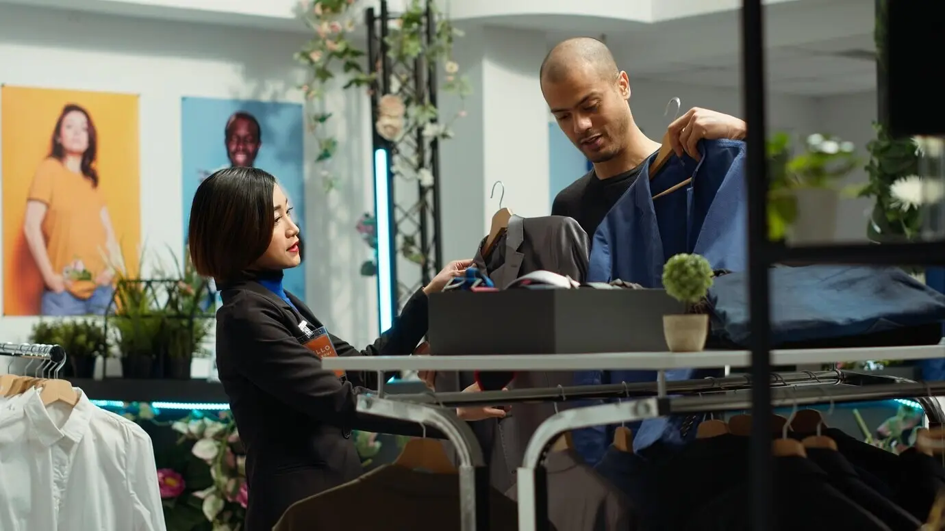 Разные люди обсуждают модные тенденции и ассортимент в розничном магазине.